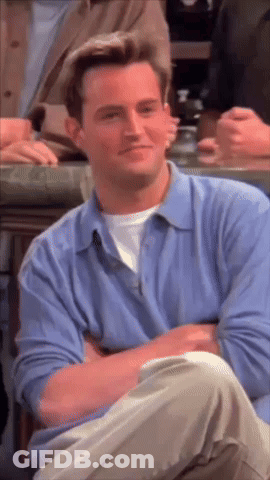 Man In Blue Shirt Sitting With Arms Crossed Smiling GIF