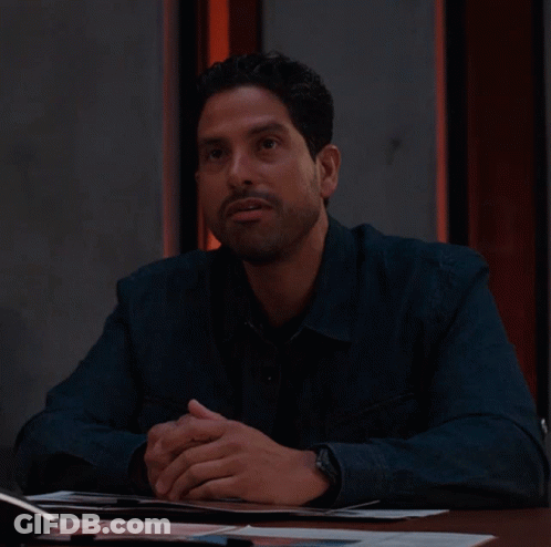 Man In Blue Shirt Sitting With Hands Folded GIF