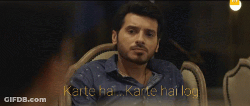 Man In Blue Shirt Sitting With Karte Hai Karte Hai Log GIF