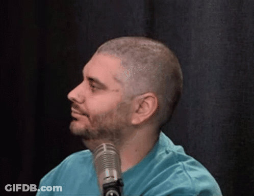 Man In Blue Shirt Smiling At Microphone GIF