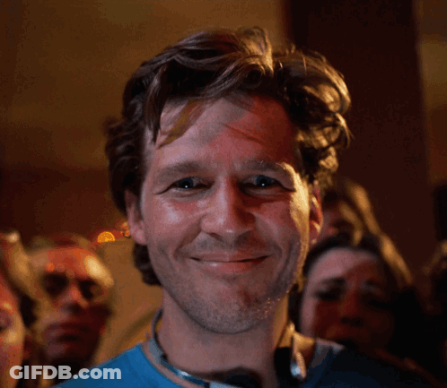 Man In Blue Shirt Smiling In Front Of Crowd GIF