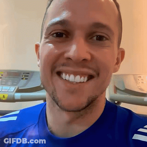 Man In Blue Shirt Smiling In Front Of Treadmill GIF
