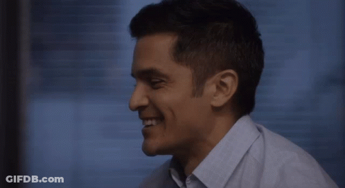 Man In Blue Shirt Smiling Looking Down GIF