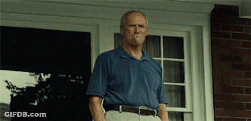 Man In Blue Shirt Smoking Cigarette On Porch GIF