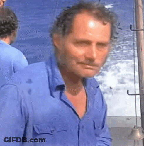 Man In Blue Shirt Standing At Ocean GIF