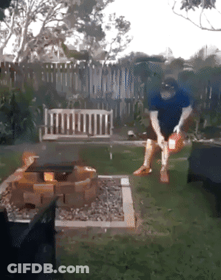 Man In Blue Shirt Standing By Fire Pit GIF
