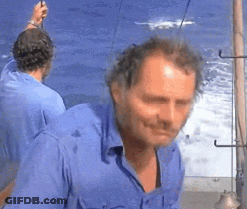 Man In Blue Shirt Standing By Ocean GIF