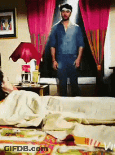 Man In Blue Shirt Standing In Bedroom GIF