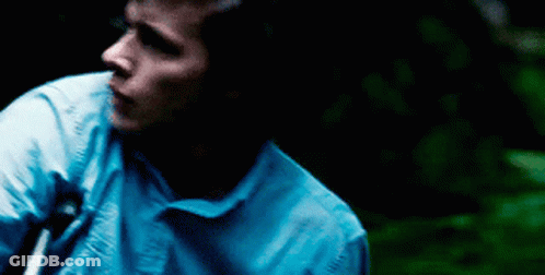 Man In Blue Shirt Standing In Darkness GIF