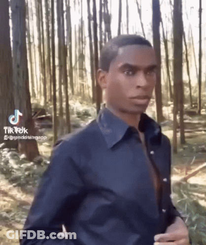 Man In Blue Shirt Standing In Forest GIF