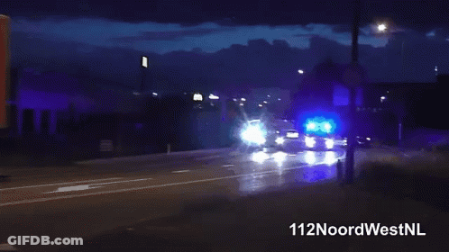 Man In Blue Shirt Standing In Front Of Blue Light GIF
