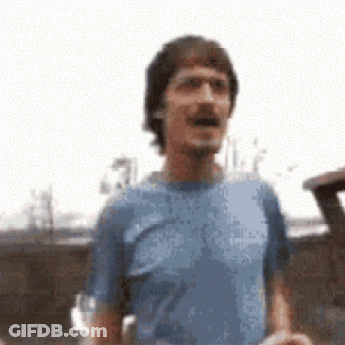 Man In Blue Shirt Standing In Front Of Car GIF