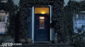 Man In Blue Shirt Standing In Front Of Door GIF