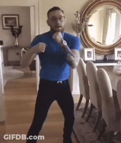 Man In Blue Shirt Standing In Front Of Mirror GIF