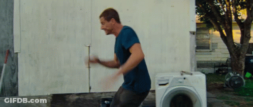 Man In Blue Shirt Standing In Front Of Washing Machine GIF