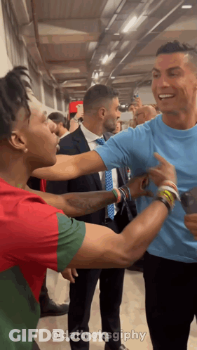 Man In Blue Shirt Standing Next To Another Man GIF