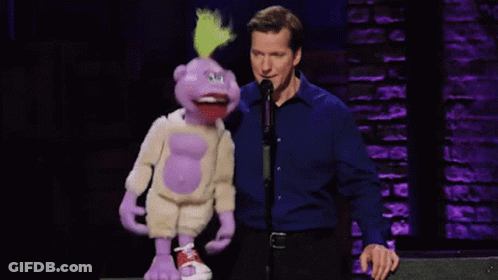 Man In Blue Shirt Standing Next To Puppet GIF