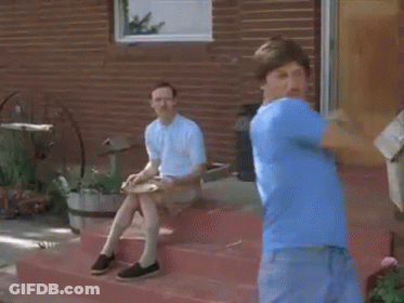 Man In Blue Shirt Standing On Steps With Sitting Man GIF