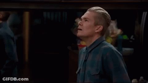 Man In Blue Shirt Standing With Mouth Open In Dark Room GIF