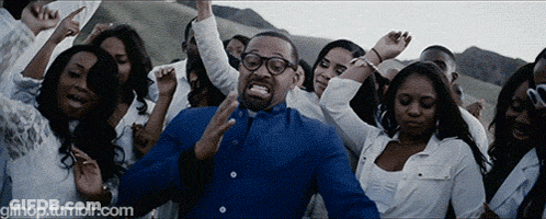 Man In Blue Shirt Surrounded By Dancing Crowd GIF