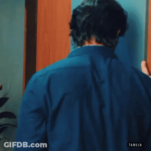 Man In Blue Shirt Talking On Cell Phone GIF