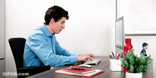 Man In Blue Shirt Typing At Desk GIF