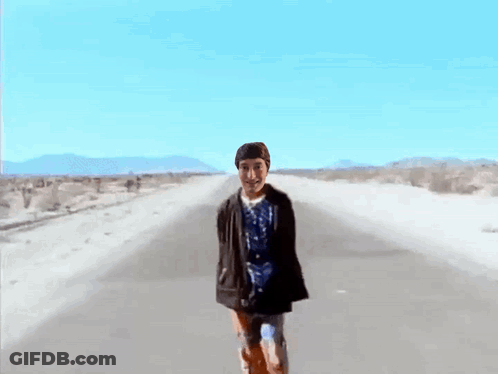 Man In Blue Shirt Walking Desert Road GIF