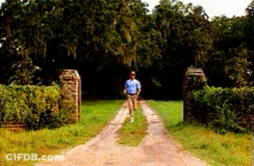 Man In Blue Shirt Walking Past Welcome Sign GIF
