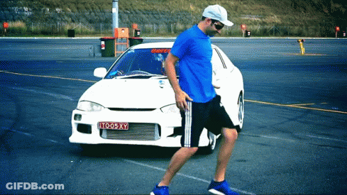 Man In Blue Shirt Walking Past White Car License Plate TO05XY GIF