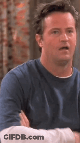 Man In Blue Shirt With Arms Crossed Making Funny Face GIF