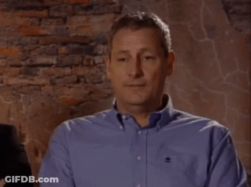 Man In Blue Shirt With Black Embroidered Logo GIF