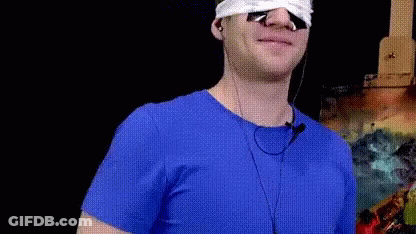 Man In Blue Shirt With Earbuds GIF