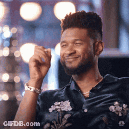 Man In Blue Shirt With Flowers Smiling In Front Of Mirror GIF