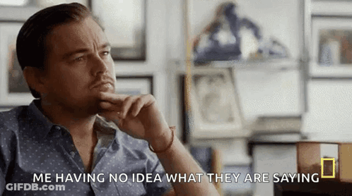 Man In Blue Shirt With Hand On Chin GIF