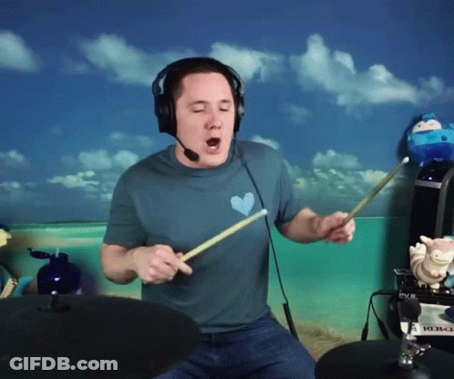 Man In Blue Shirt With Heart Playing Drums GIF