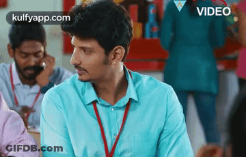 Man In Blue Shirt With Lanyard Sitting GIF
