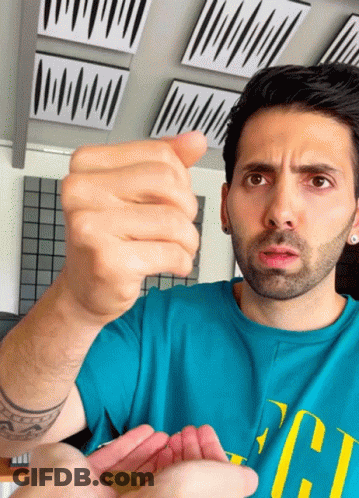Man In Blue Shirt With Letter C Holding Coin GIF