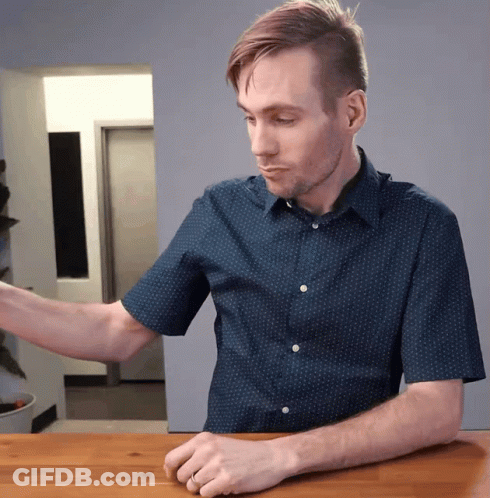 Man In Blue Shirt With White Polka Dots Sitting At Table GIF