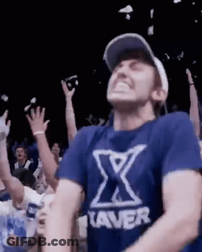 Man In Blue Shirt With X Dancing In Crowd GIF