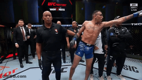 Man In Blue Shorts In Front Of UFC Sign GIF