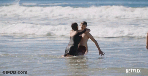 Man In Blue Shorts Standing In Ocean GIF