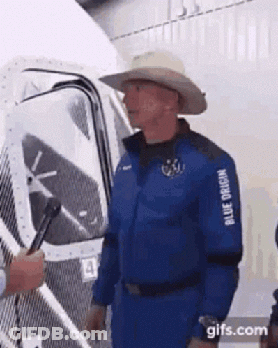 Man In Blue Suit And Cowboy Hat Standing In Front Of Building GIF