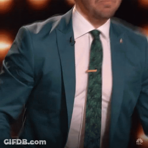 Man In Blue Suit And Green Tie At Microphone GIF