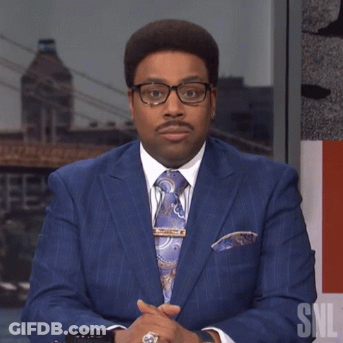 Man In Blue Suit And Tie Beside SNL Logo GIF