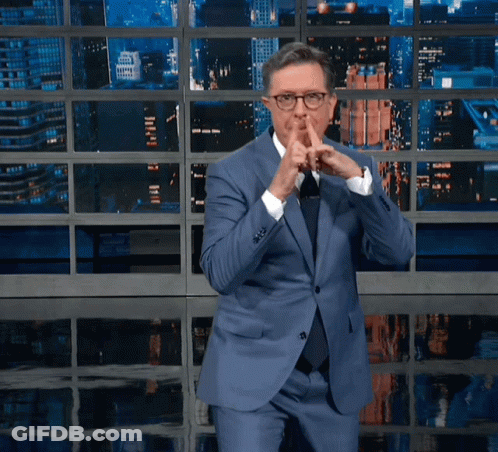 Man In Blue Suit And Tie Shushing GIF