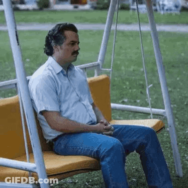 Man In Blue Suit And Tie Sitting In Front Of Postgame Live Sign GIF