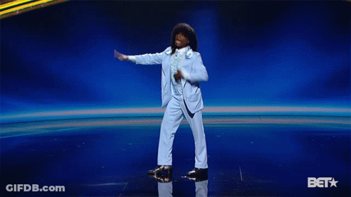 Man In Blue Suit Dancing On Stage With BET Logo GIF