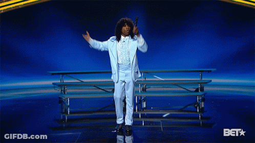 Man In Blue Suit Holding Microphone In Front Of Bet Star GIF