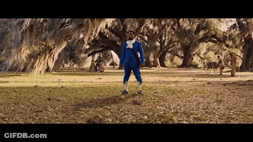 Man In Blue Suit In Field With Trees GIF