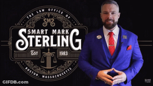 Man In Blue Suit In Front Of Smart Mark Sterling Logo GIF